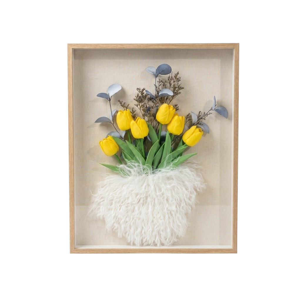 A framed floral wall art piece featuring yellow tulips with green leaves, blue-gray foliage, and a fluffy white textured base inside a light wood shadow box on a white background.