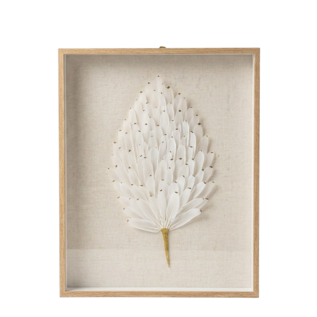 A framed botanical wall art piece featuring a white dried palm leaf with small gold accents, mounted on a textured beige linen background inside a light natural wood frame.