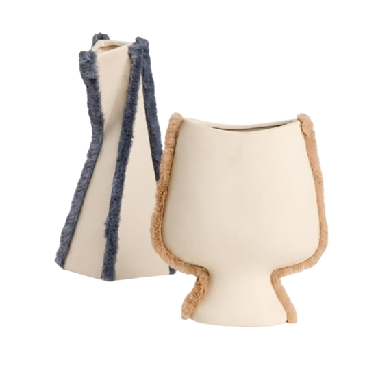 Two modern ceramic vases on a plain white background. One vase is cream-colored with dark blue frayed trim, and the other is cream-colored with light brown frayed trim.