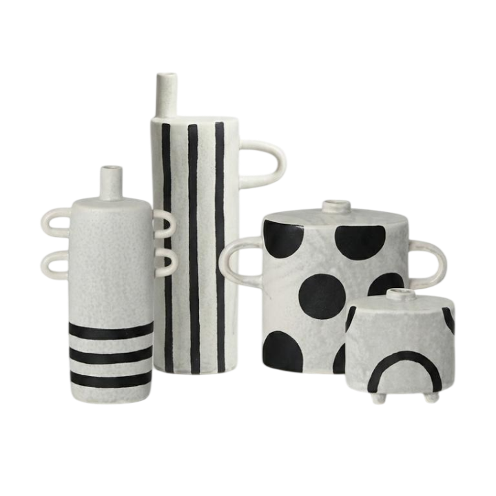 A set of four modern ceramic vases with black and white patterns, including stripes, polka dots, and curved lines, arranged on a plain white background.
