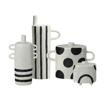 A set of four modern ceramic vases with black and white patterns, including stripes, polka dots, and curved lines, arranged on a plain white background.