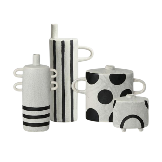 A set of four modern ceramic vases with black and white patterns, including stripes, polka dots, and curved lines, arranged on a plain white background.