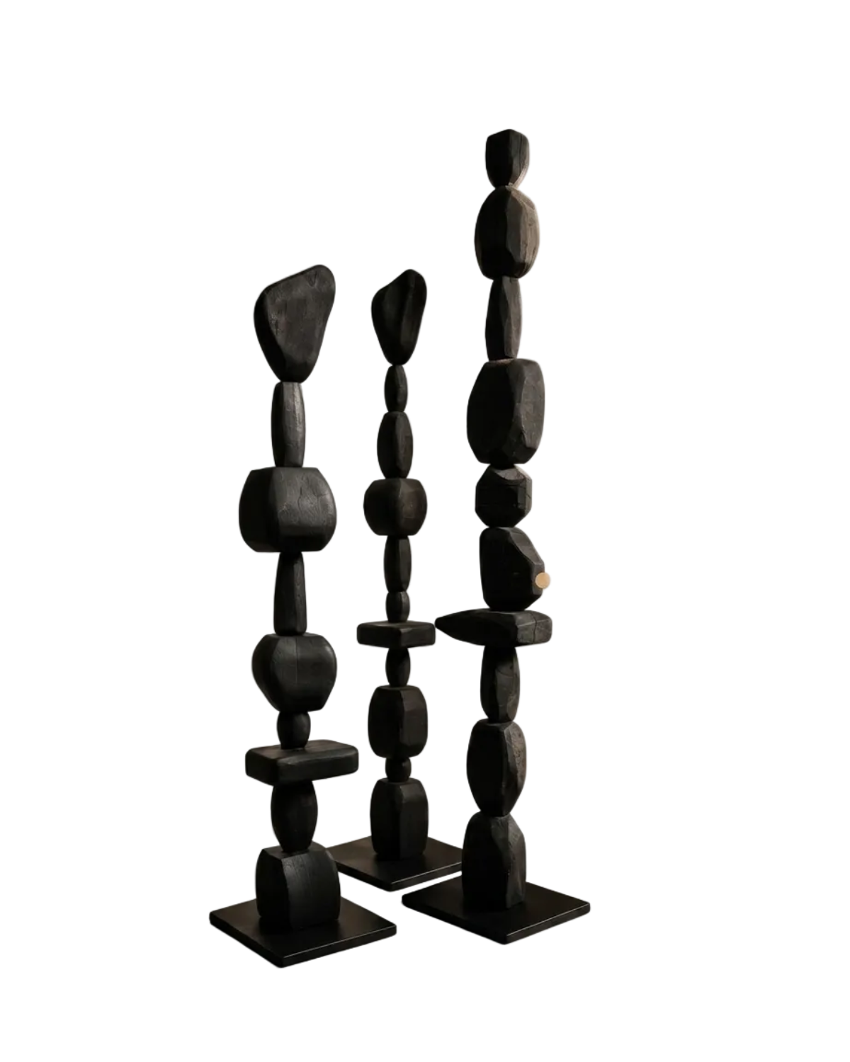 Three black stone sculptures on a white background