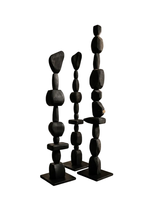 Three black stone sculptures on a white background