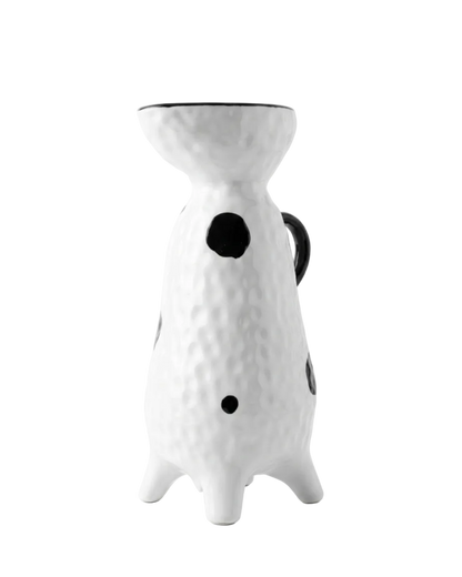White ceramic pitcher with black dots on a white background