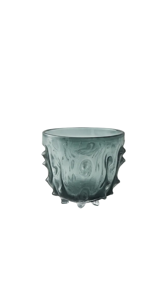 Green glass cup with textured surface on a white background