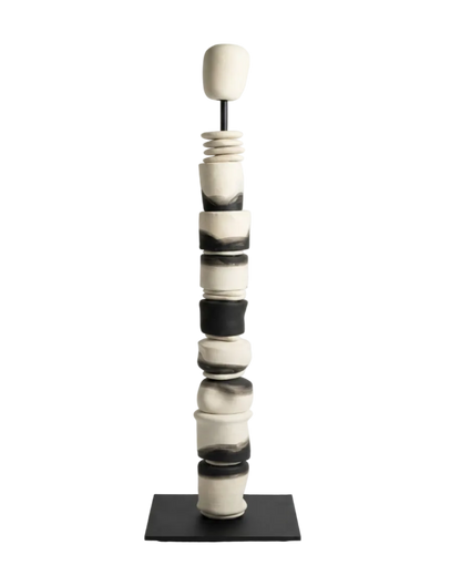Black and white ceramic sculpture on a stand against a white background