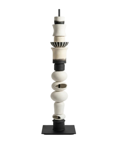 Cylindrical ceramic sculpture with black and white colors on a white background