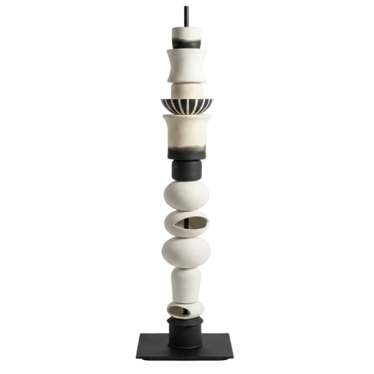 Cylindrical ceramic sculpture with black and white colors on a white background