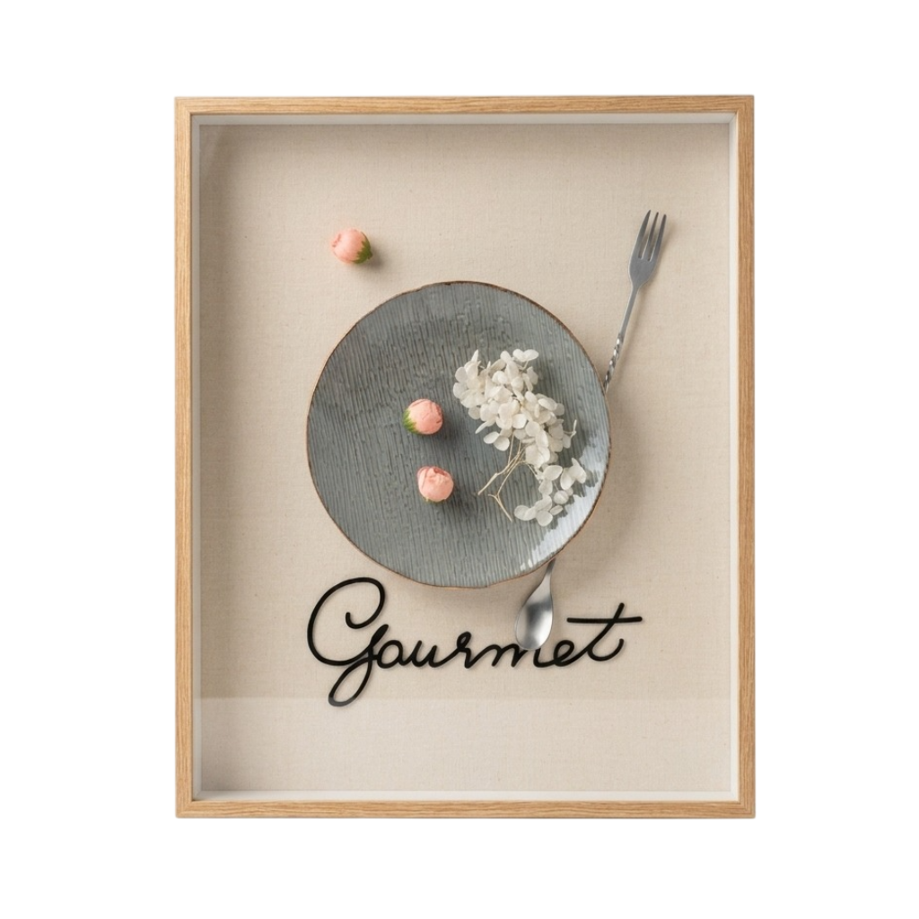 A framed wall art print featuring a minimalist food still life with a gray plate, dried white flowers, pink candy pieces, a fork, and the word 'Gourmet' in black script on a beige background, enclosed in a light wood frame.